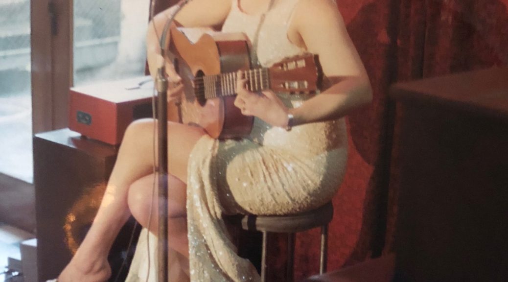 Doris Goddard sings with guitar back in the day.