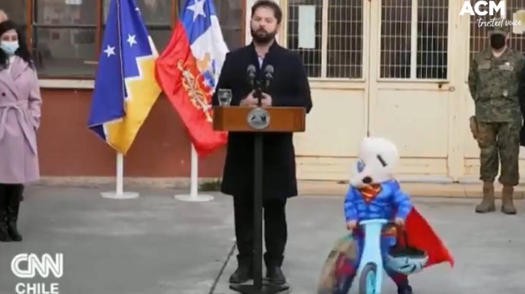 Kid on bike during Chile president press conference.