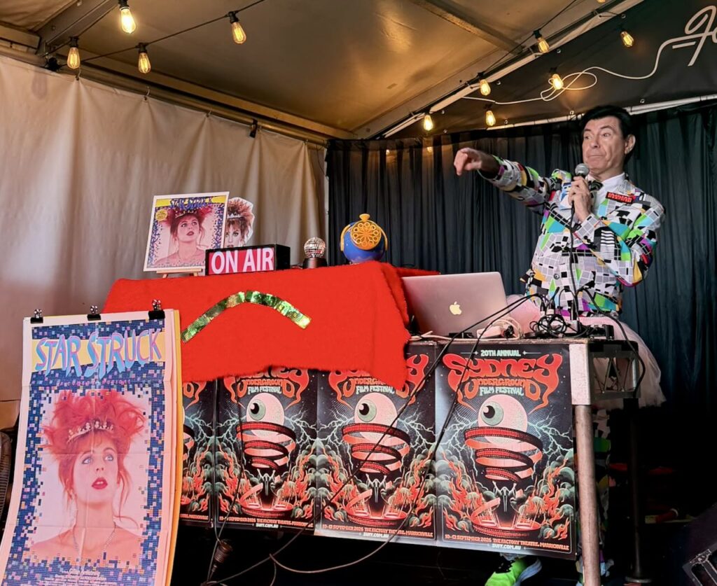 Maynard points to crowd in front of him while he DJs. Starstruck screening Sydney Underground Film festival 2026.